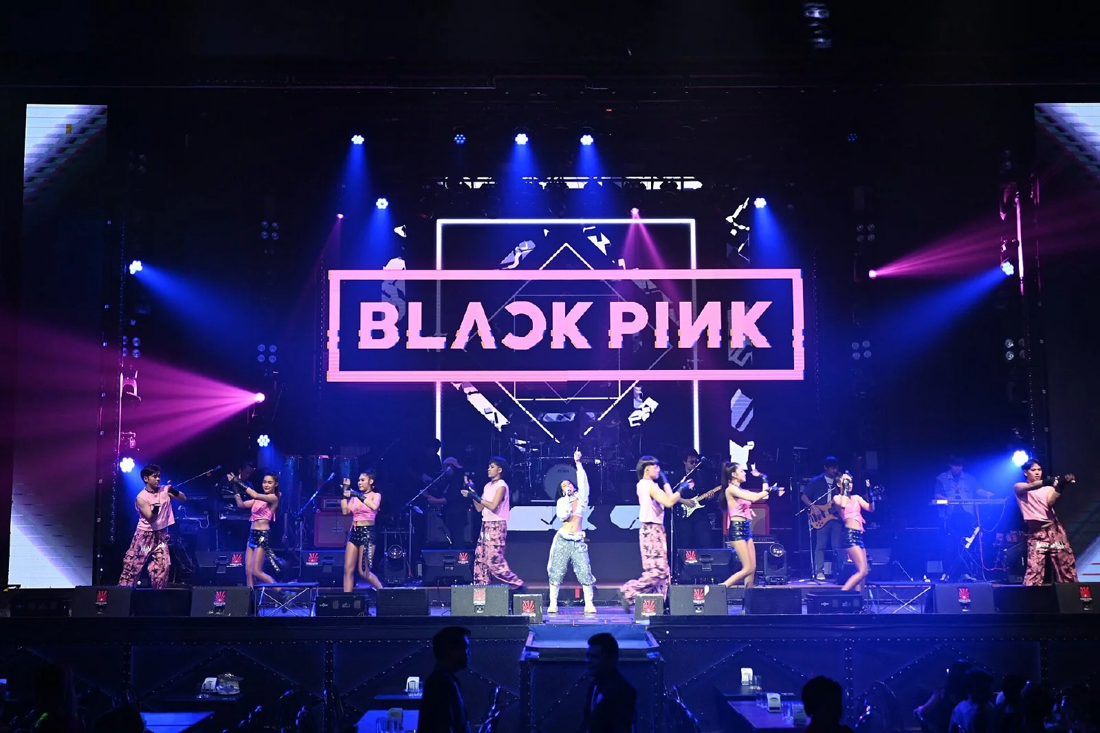 분홍색과 파란색 조명을 받은 블랙핑크 콘서트 무대와 공연자들