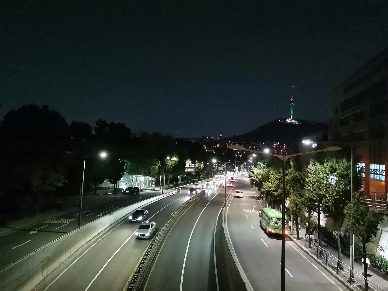 밤에 불이 켜진 이태원 거리의 상점과 도로