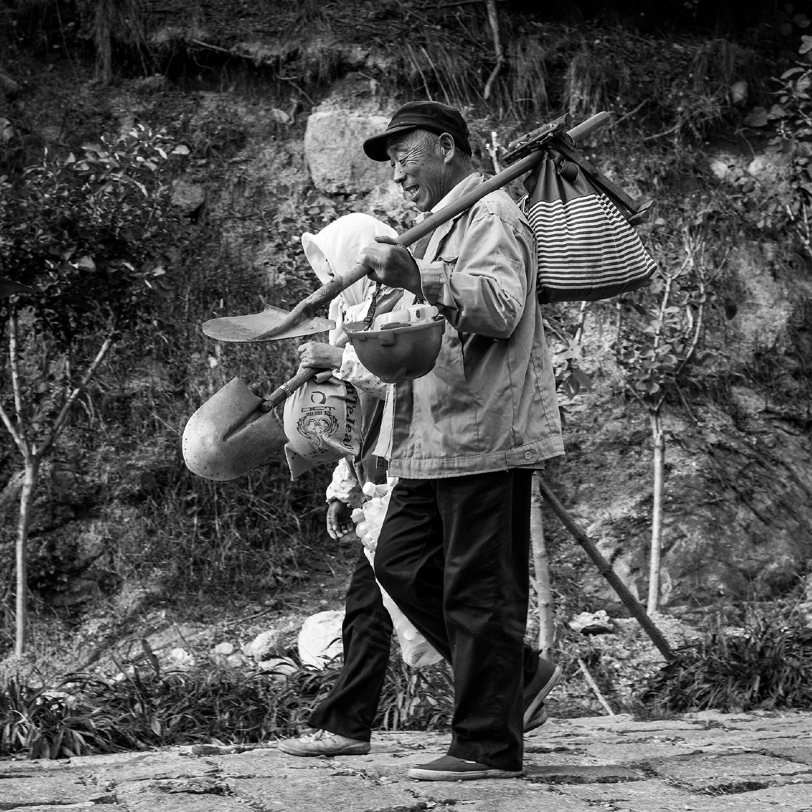 산길에서 함께 이동하는 여러 명의 고령 근로자